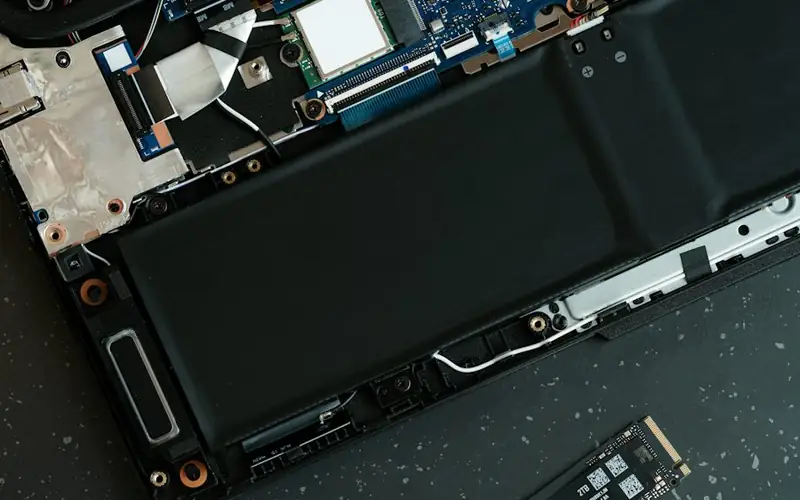 An opened laptop taken apart on a workbench